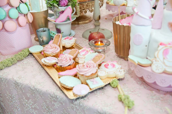 Wedding decoration with pastel colored cupcakes, meringues, muffins and macarons. Elegant and luxurious event arrangement with colorful macaroons. Wedding dessert with macaroons