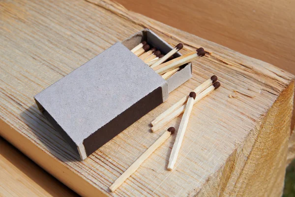 Open matchbox and matches on the wood