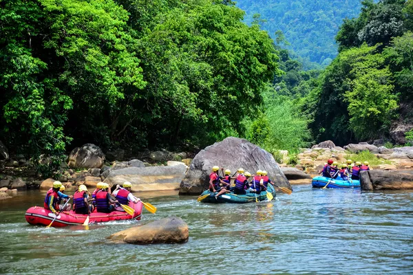 A group of men and women white water rafting