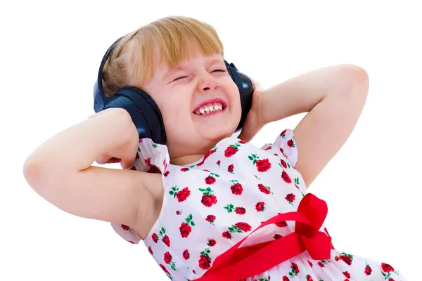 Charming little girl loves to listen to music through headphones