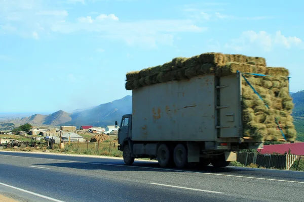 Truck with hay on a mountain road