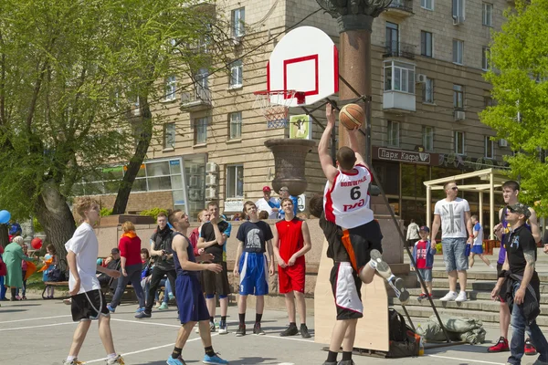 Teenagers play streetball on the open-air asphalt ground