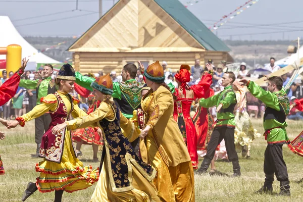 Men and women in national costumes dance traditional folk dances
