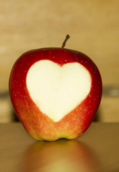 Red apple with a carved heart shape on it