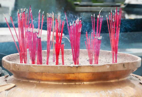 Burning incense sticks in Brass Incense Bowl at buddhist shrine