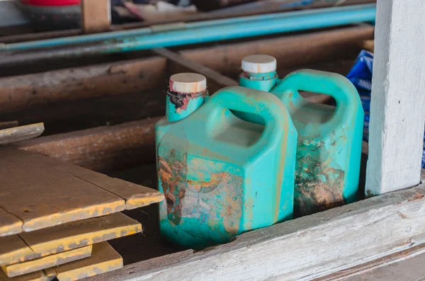 Old dirty green plastic oil gallon in garage