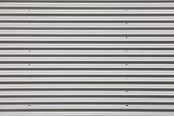 Wide shot of silver corrugated metal with bolts