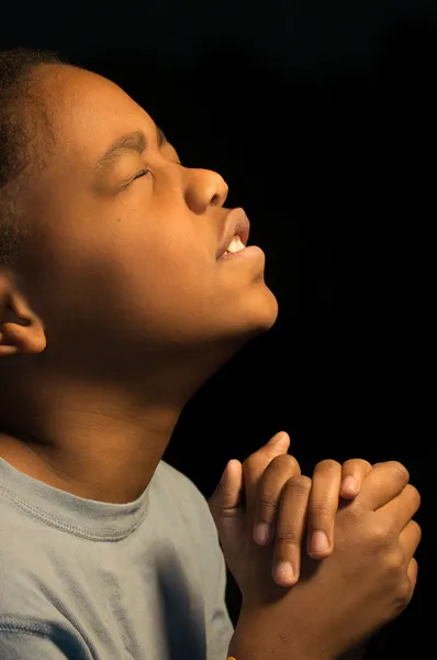 Praying African American boy