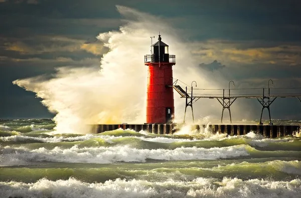 Wave slamming red lighthouse