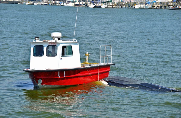 Tow boat with capsized boat