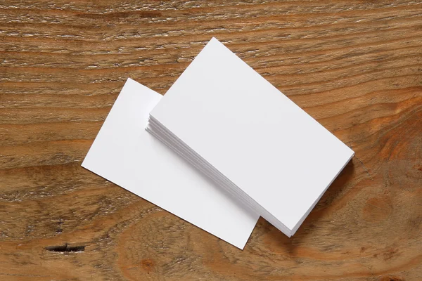 Stack of blank business cards on wooden background