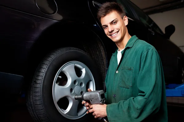 Auto mechanic changing wheel