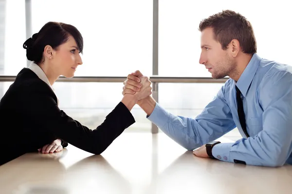 Businessman and businesswoman arm wrestling — Stock Photo #25735233