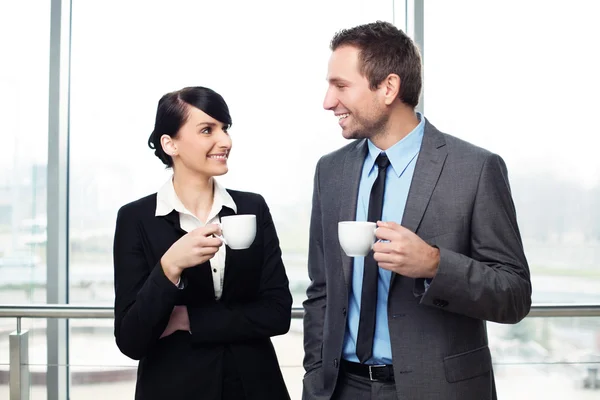 Businessman and businesswoman drinking coffee