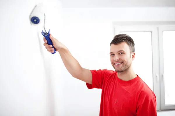 Happy young man painting wall