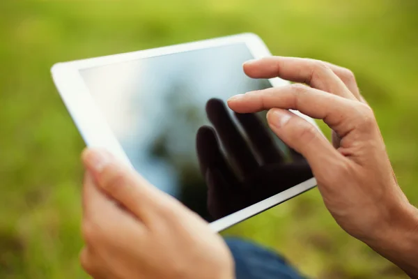 Young woman using digital tablet in park