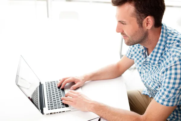 Happy handsome man working with laptop