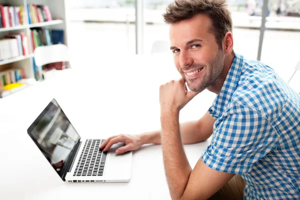 Handsome happy man working with laptop