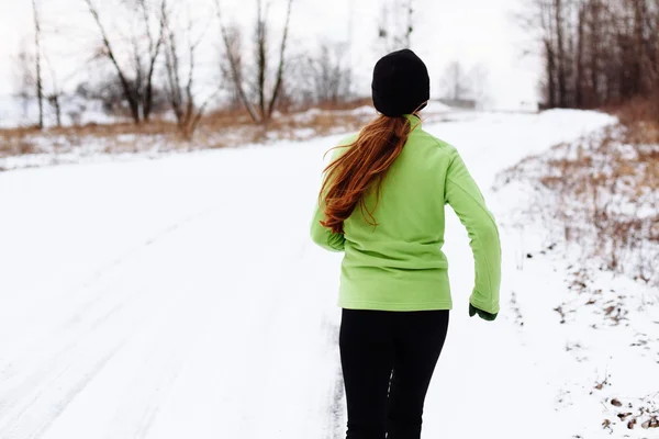 Woman running in winter snow