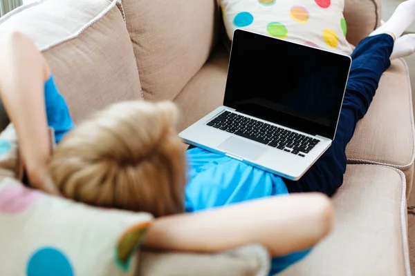Woman relaxing with laptop on couch