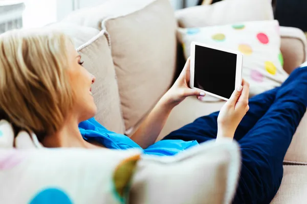 Happy woman with tablet on couch