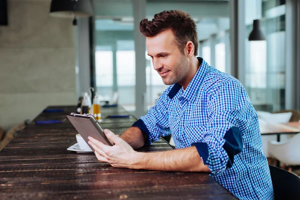 Man looking at his tablet in cafe