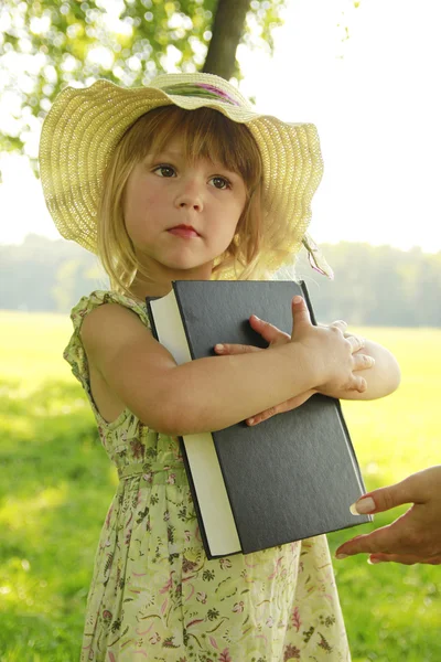 Little girl reading the Bible in nature
