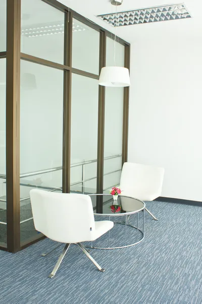 Office building with furniture and a white wall