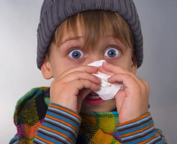 Boy wipes his nose