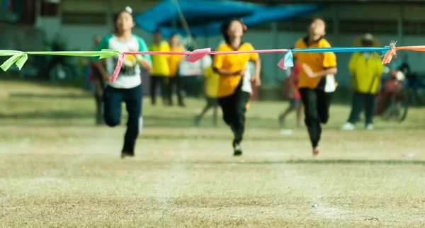 Child girl sprinting to finish line in sport day of school