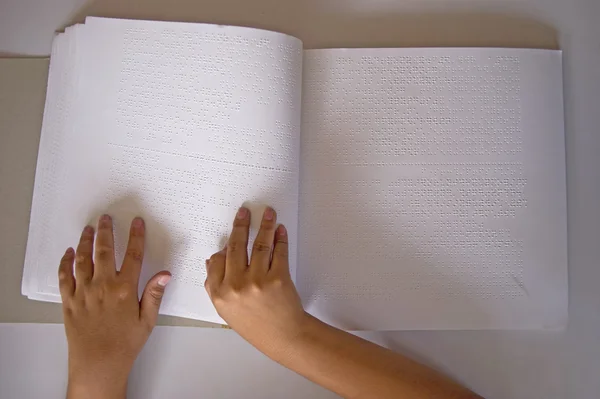 Fingers and braille. blind read a book in braille.