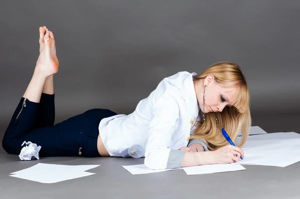 Modern student writes lying on the floor