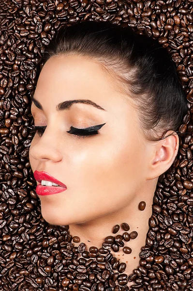 Face with closed eyes in the coffee beans