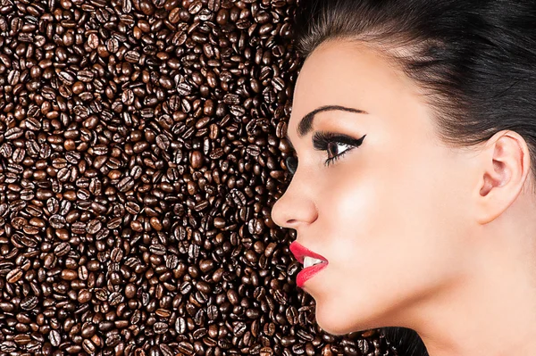 Face of a beautiful woman in coffee beans