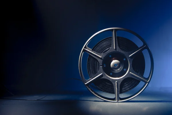 Movie spool with film and dramatic lighting