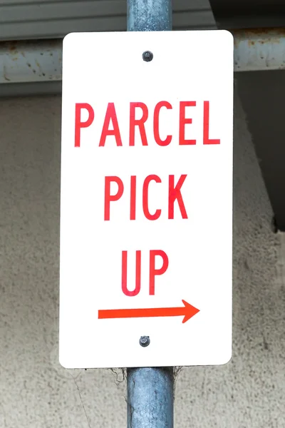 Dirty Sign Stating PARCEL PICK UP with Right Arrow