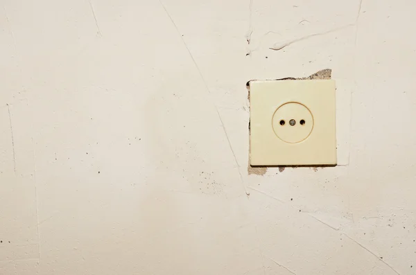 Socket in the wall.Plastic socket mounted in a concrete wall putty