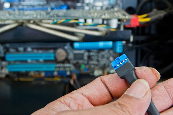 Close up of a technician\'s hands wiring computer parts