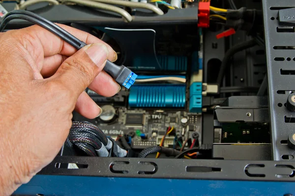 Close up of a technician\'s hands wiring computer parts