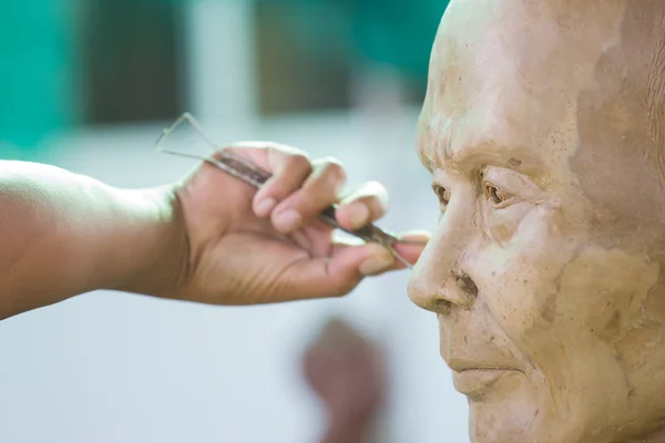 Sculpture Tool. artisan creates the head of a Buddhist mon