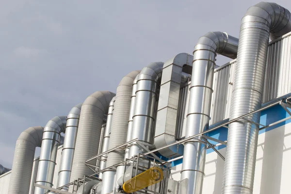 Pipes on exterior of modern factory building.