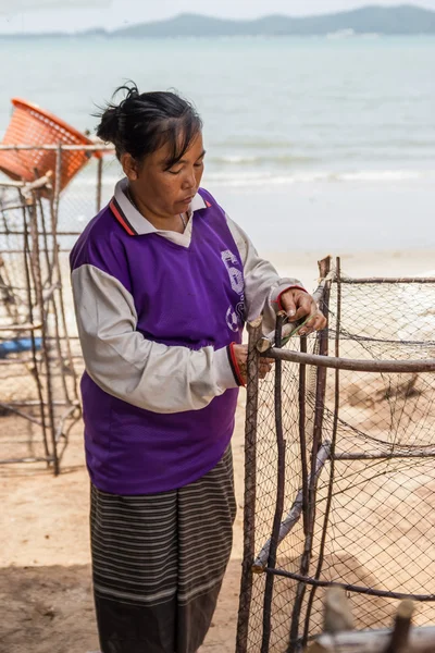 Woman fishermen is weaving fish-trap