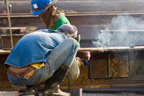 Outdoor worker with protective mask welding metal and sparks