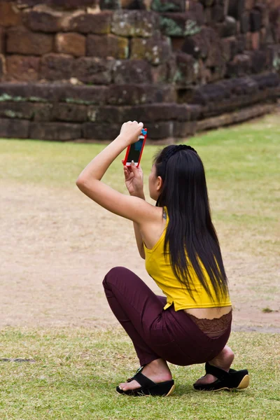 Young woman is taking photos with the mobile phone camera,