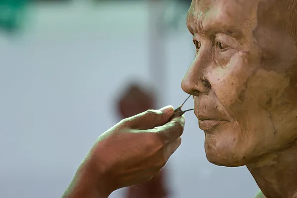 Sculpture Tool. artisan creates the head of a Buddhist monk