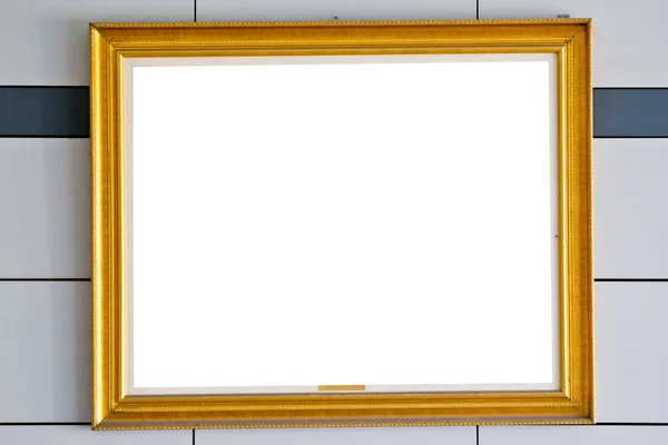 Gold picture frame. Isolated over wall background