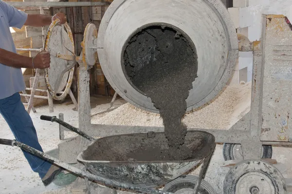 Worker uses a concrete of a concrete mixer
