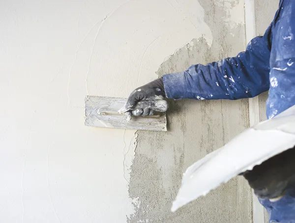 Worker plastering tool plaster marble on interior plaster rough