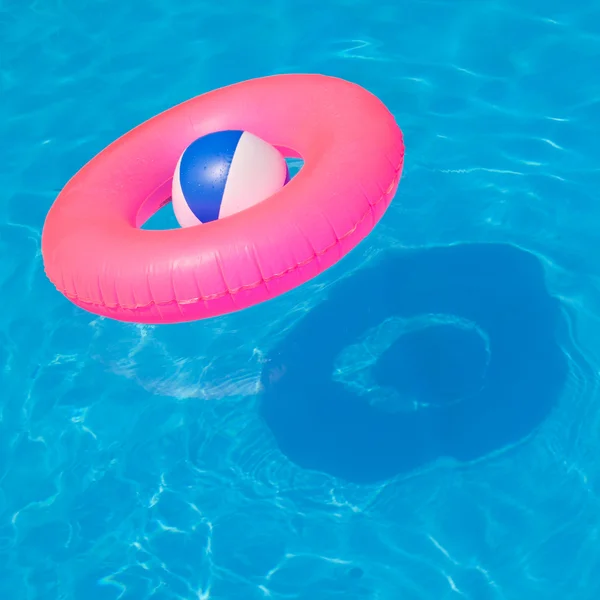 Pink pool float, pool ring in cool blue refreshing blue pool