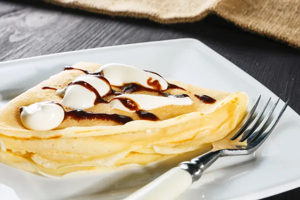 Crepe with whipped cream and chocolate sauce